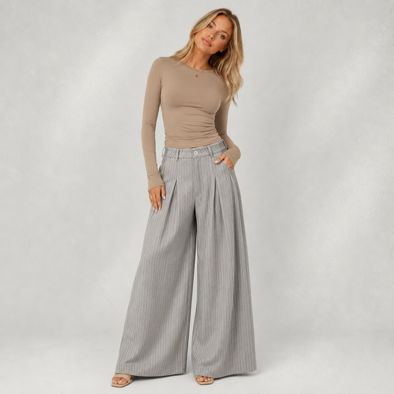 Pantalon femme gris à rayures, coupe large plissée, porté avec un haut beige