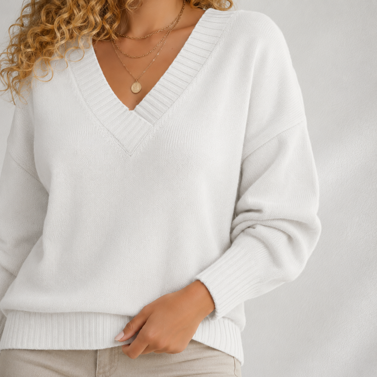 Détail des manches longues et de la base côtelée d’un pull femme blanc