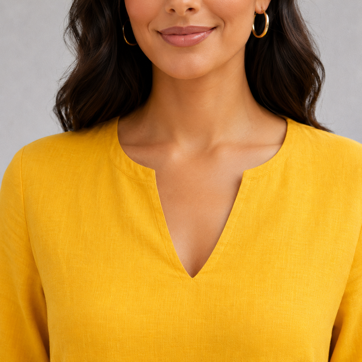 Gros plan sur le col V d’une robe d’été jaune en tissu effet lin doux